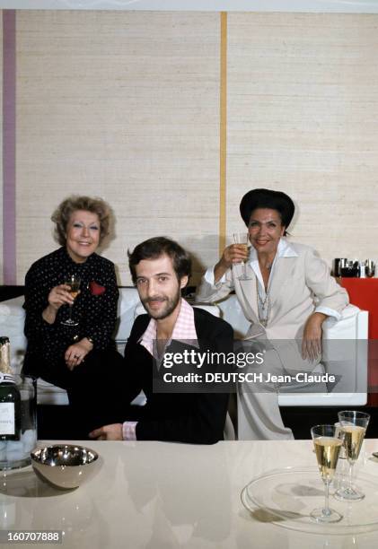 The Big Names Of Hairdressing. Paris - 1976 - Assise dans des fauteuils blancs, chacune une coupe de champagne à la main, la coiffeuse Maria CARITA,...