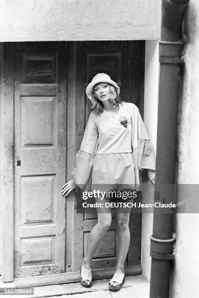 Summer 1971 Fashion In Saint-tropez. A Saint-Tropez, Rosalind MURRAY, adossée à une porte de maison, portant pour la marque JAP, une blouse à manches...