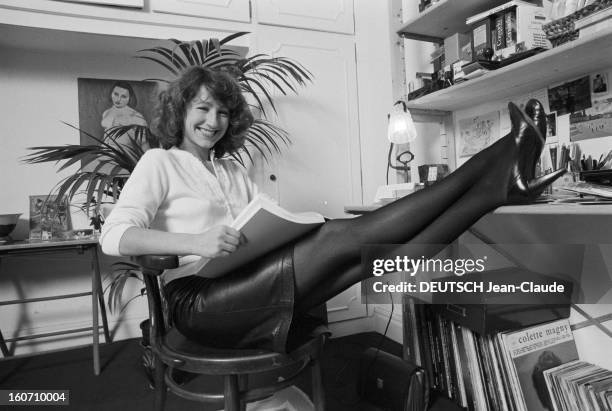 Nathalie Baye. En France, le 26 décembre 1981, L'actrice Nathalie BAYE chez elle, portant une jupe en cuir et des collants noirs, assise sur une...