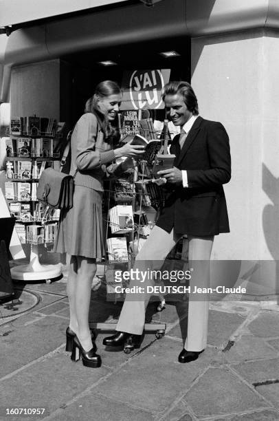 Fashion - Shoes With Compensated Insoles. France-2 Octobre 1972- Mode des talons compensés: un couple de mannequins homme-femme devant un kiosque...
