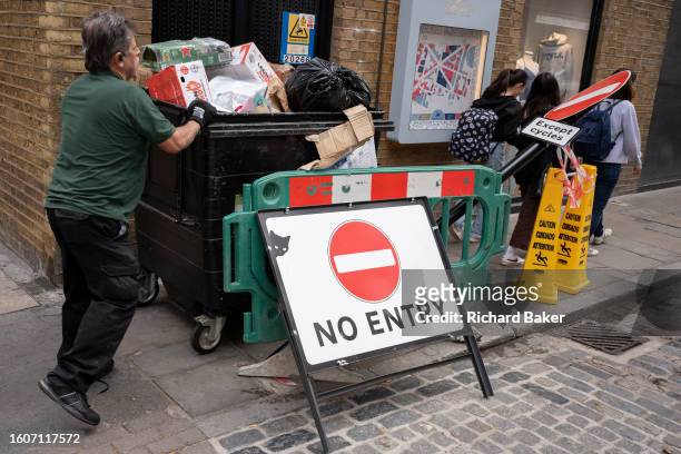 Pedestrians walk past the bent and damaged No Entry sign post on Neal Street, on 13th August 2023, in London, England.