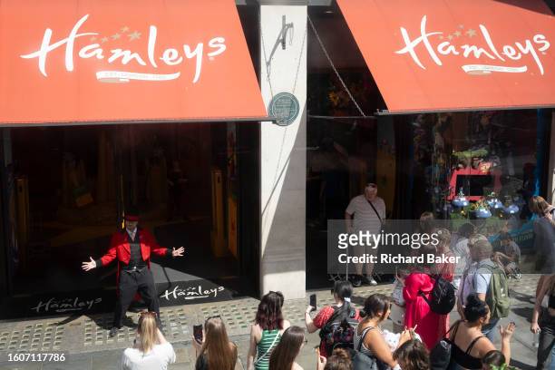 An entertainer performs a song and dance routine for shoppers outside toy shop Hameys on Regent Street, on 16th August 2023, in London, England.