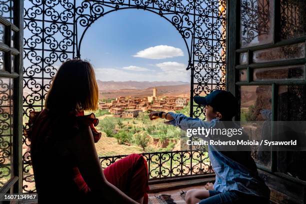 boy with mother admiring telouet kasbah, morocco - atlasgebirge stock-fotos und bilder