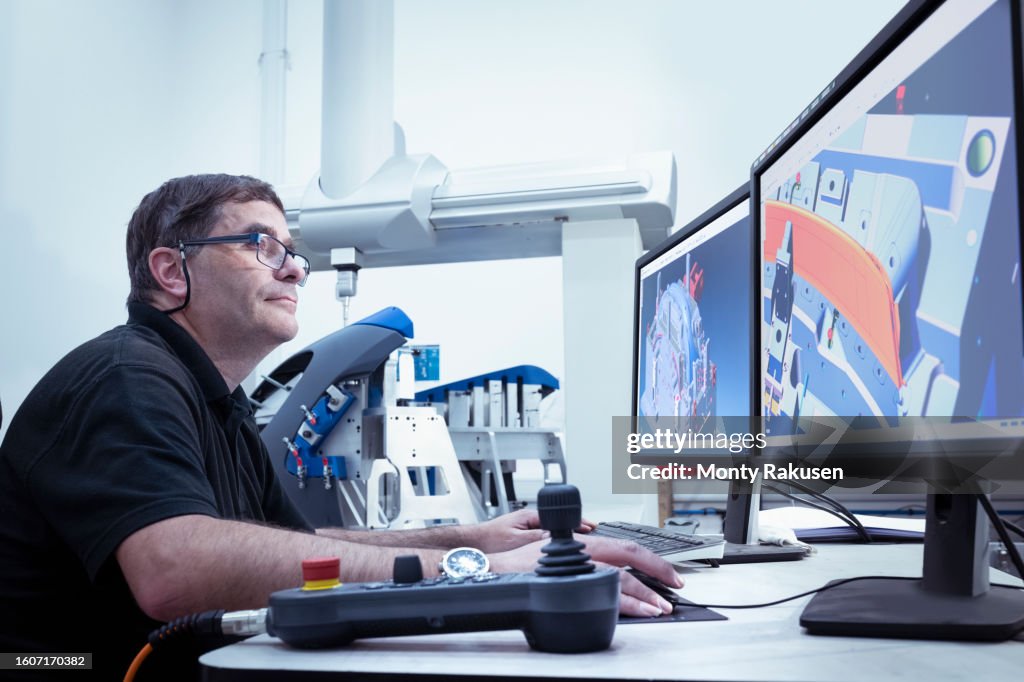 Worker inspecting injection moulded plastic parts in laboratory in automotive parts factory