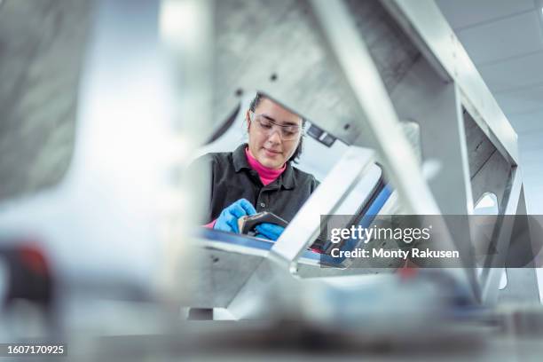 worker assembling carbon fibre automotive parts in jig in automotive parts factory - carbon fibre stock pictures, royalty-free photos & images