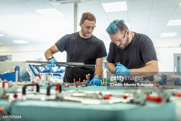 workers gluing carbon fibre in automotive parts factory - carbon fibre stock pictures, royalty-free photos & images