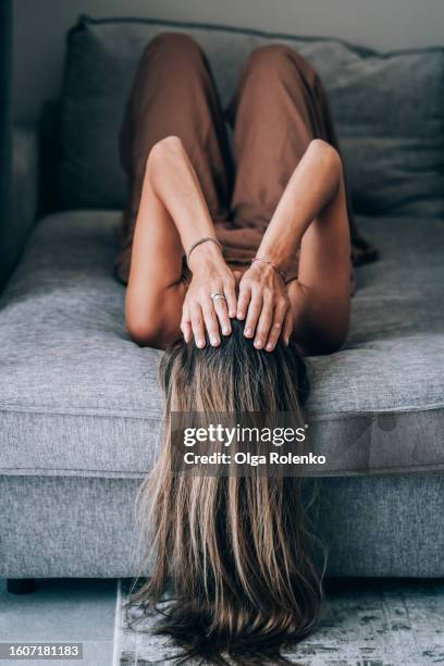 challenge of depression, insomnia, and mental illness. sad woman hides her face in hands, lying on bed. upside down view - head in hands stock pictures, royalty-free photos & images