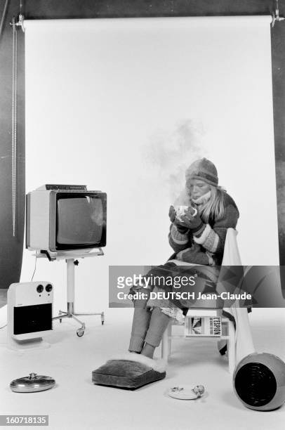 Energy Savings How To Be Less Cold This Winter. 1977, un mannequin présente diverses tenues pour l'hiver : dans un studio, la jeune femme pose assise...
