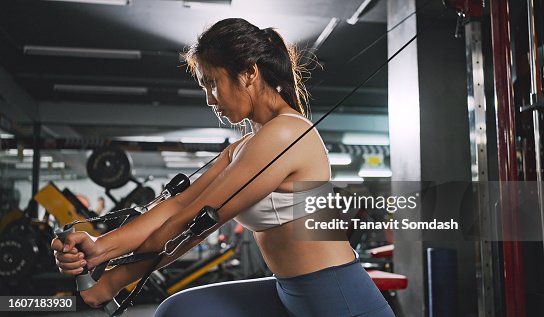 Sportliche Frau, die auf der Multistation im Fitnessstudio für Arm- und Schultermuskeln trainiert. Fitnesstraining im Fitnessstudio. Sportliche Frau, die auf der Multistation im Fitnessstudio für Arm- und Schultermuskeln trainiert. Fitnesstraining im Fitnessstudio.