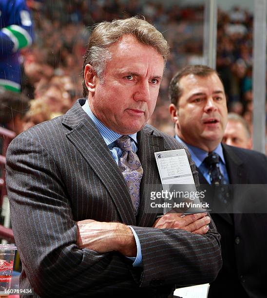 Associate coach Rick Bowness of the Vancouver Canucks and head coach Alain Vigneault look on from the bench during their NHL game against the...