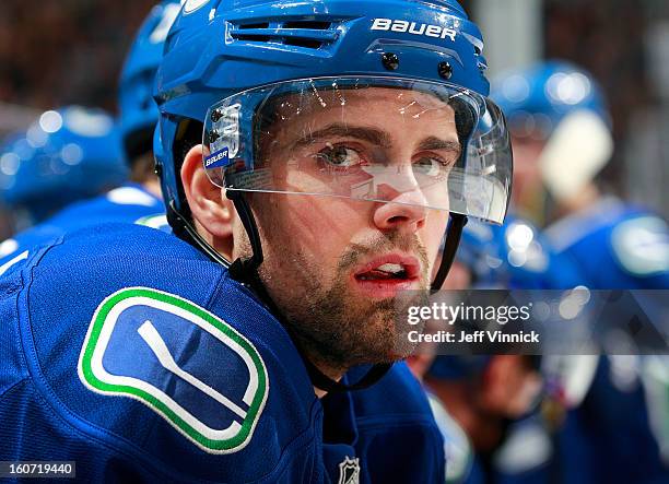 Dan Hamhuis of the Vancouver Canucks looks on from the bench during their NHL game against the Colorado Avalanche at Rogers Arena January 30, 2013 in...