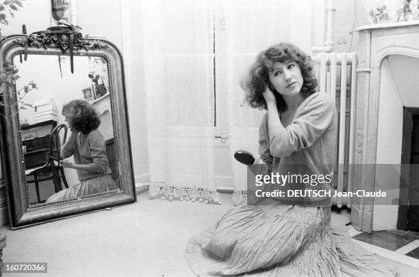 Nathalie Baye. En France, le 26 décembre 1981, L'actrice Nathalie BAYE chez elle, assise par terre dans son salon, à coté d'un miroir, se coiffant...