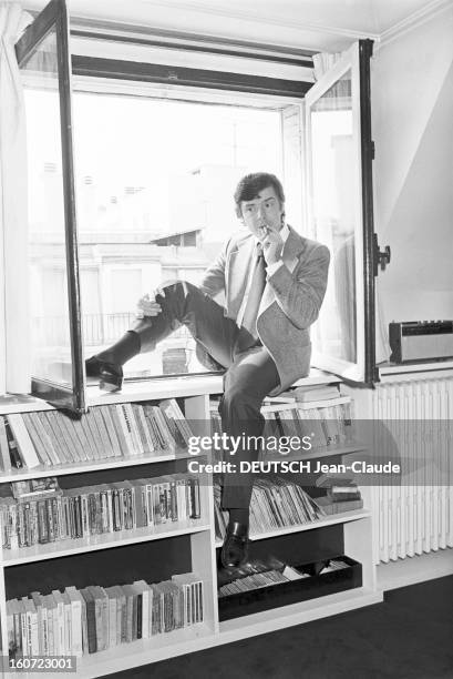 Writer Pascal Garden At Home. A Paris, dans sa garçonnière du XVIème arrondissement, portrait de l'écrivain Pascal JARDIN, assis sur un rayonnage de...