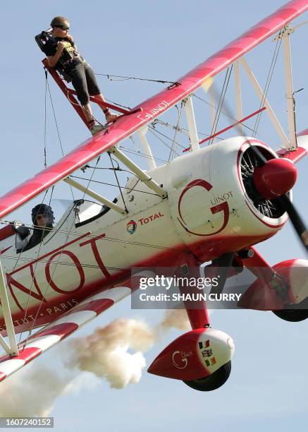 Tiger Brewer, an eight year-old British boy, attaches himself onto the wings of his grandfather's biplane, in Cirencester, in southern England, on...