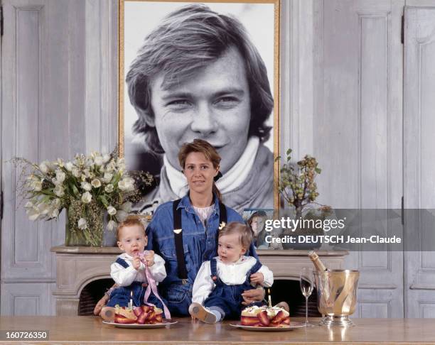 Rendezvous With Catherine Pironi And Her Twins Gilles And Didier. Rambouillet - 23 décembre 1988 - Chez elle, devant un grand portrait de son mari...