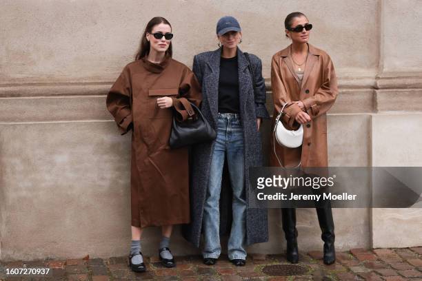 Annabel Rosendahl is seen wearing black oval sunglasses, silver earrings, brown long coat and cape, black leather handbag, grey wool socks, black...