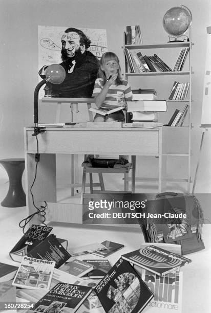 Education - School Supplies. Paris- 8 Septembre 1977- Enseignement et fournitures scolaires: une fillette pose assise à un bureau scolaire, un stylo...