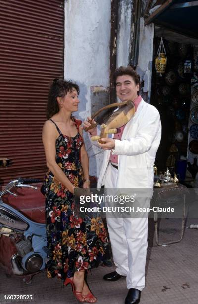 Serge Lama And His Wife Michele In Morocco. Marrakech - juin 1992 - A l'occasion de leur lune de miel, devant une échoppe dans un souk, Michèle LAMA...