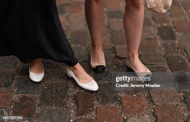 Gine Margrethe is seen wearing a black silk long skirt and Prada white shiny leather ballerinas; A guest wears Chanel beige leather ballerinas,...