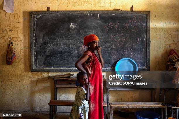 Woman looks out onto the street with her daughter inside an IDP Center. In 2018, Abiy Ahmed took office as Ethiopia's Prime Minister. Just a year...