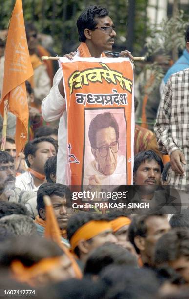 An activist of the Hindu right-wing Shiv Sena holds a poster featuring Shiv Sena supremo Bal Thackeray during a protest rally in New Delhi 03...