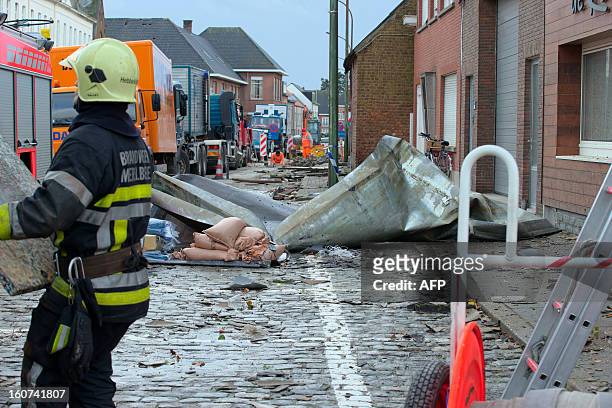 Firefighter stands in a street damaged by a whirlwind in the village of Oosterzele, East-Flanders, on February 5, 2013. AFP PHOTO/BELGA/ WIM SCHEIRE...