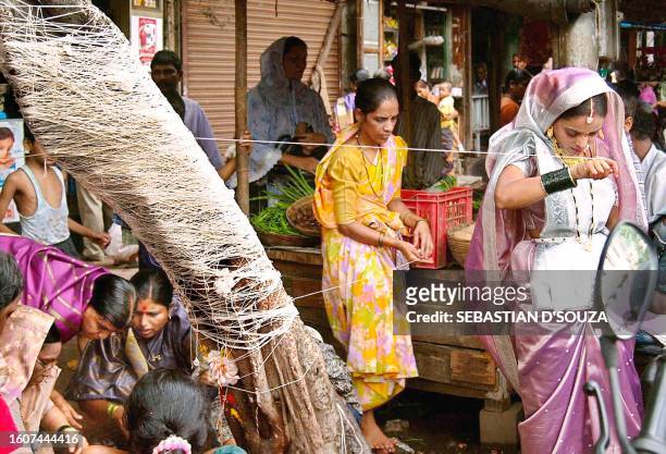 Married Hindu women perform a ritual in Bombay, 24 June 2002, and pray for their husbands longevity during "Vad Puja", the worship of the Banyan...