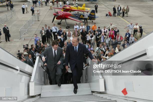 The Paris Air Show 2003. Salon de l'aéronautique au Bourget : Jacques CHIRAC montant la passerelle d'un avion suivi de nombreuses personnes dont Noël...