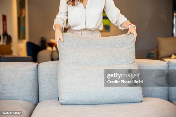woman making pillows in her living room sofa - cushion stock pictures, royalty-free photos & images