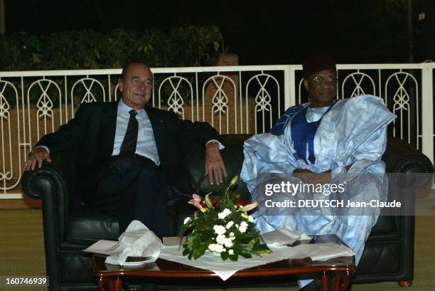 Official Visit Of Jacques Chirac In Niger. Jacques CHIRAC assis aux côtés du président Mamadou TANDJA regardant quelque chose lors d'un diner donné...