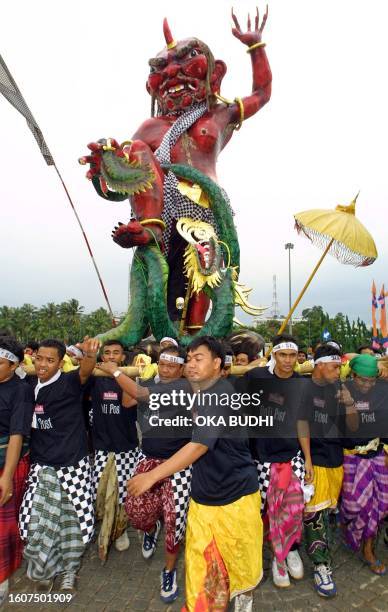 Balinese Hindus carry an Ogoh Ogoh image through Jakarta's central Monas Park 24 March on the day before the Hindu Nyepi festival, during which they...