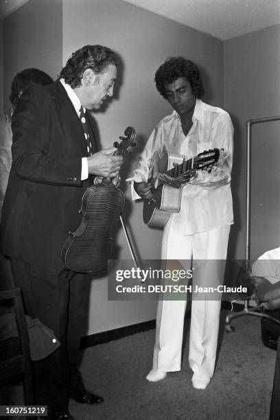 Enrico Macias In New York City. Aux Etats-Unis, à New York City, le 4 octobre 1974, son père Sylvain GHRENASSIA, violoniste, tenant son violon, et...