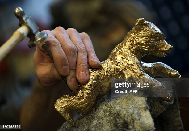 Picture taken on January 23, 2013 shows an employee of the Noack foundry working on a bear trophy for the upcoming Berlinale Film Festival in Berlin....