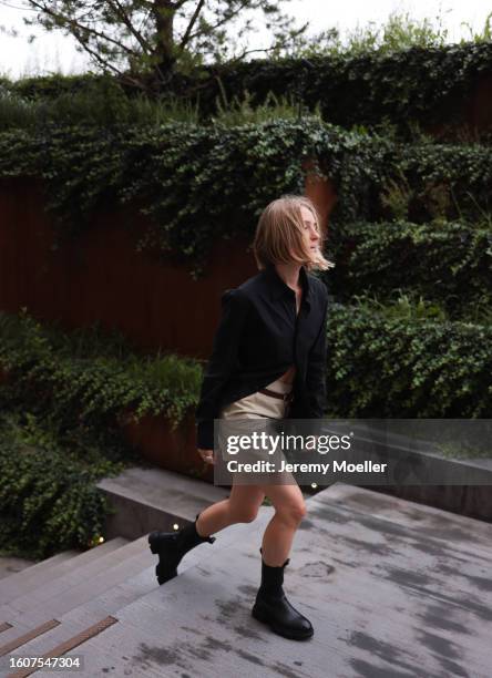 Roos Ebregt seen wearing black cotton shirt, beige short skirt, brown leather belt and Copenhagen Studios CPH500 Vitello Black leather boots, on...