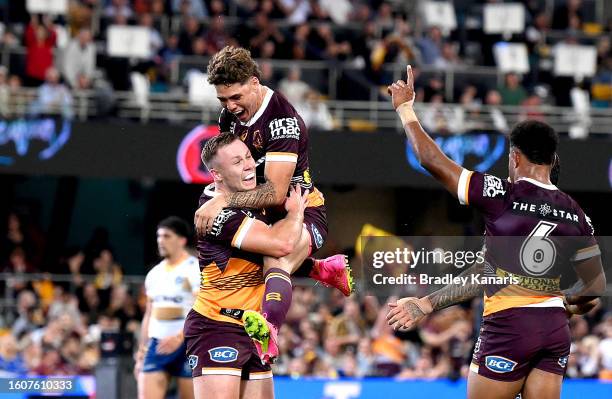 Billy Walters of the Broncos is congratulated by team mate Reece Walsh after scoring a try during the round 24 NRL match between the Brisbane Broncos...