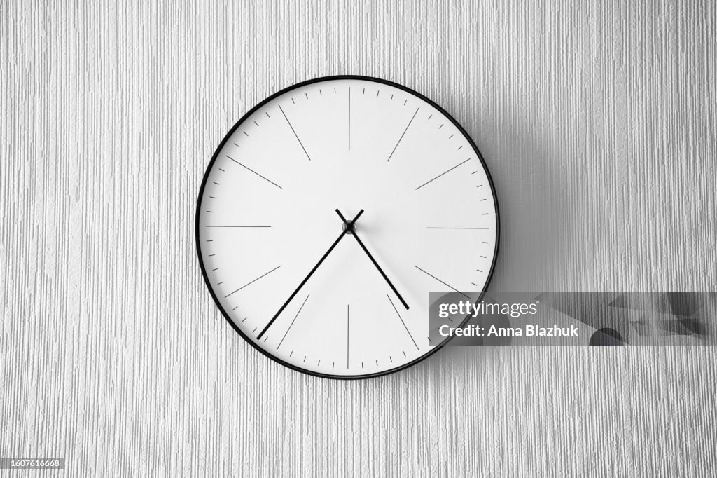 Modern minimalist black and white clock on white wall