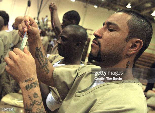 Cook County Jail detainees take an AIDS test August 7, 2001 at the jail in Chicago, Illinois. Rev. Jesse Jackson, along with several other ministers,...