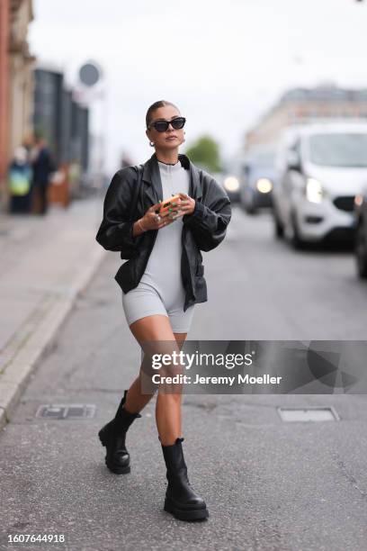 Laura Wittek seen wearing black sunglasses, light grey short jumpsuit, black leather blazer and Copenhagen Studios CPH685 Vitello Black leather...