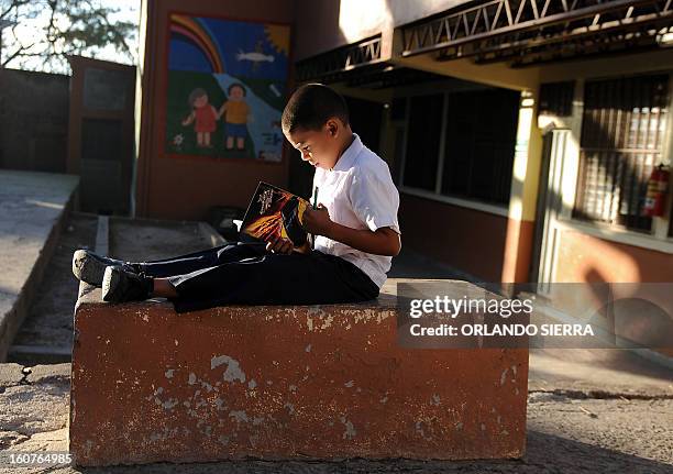 Boy reads at his school in the poor community of Las Ayestas, in Tegucigalpa on February 5, 2013. Honduras' notorious street gangs, especially the...