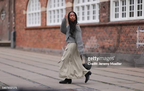 Amaka Hamelijnck seen wearing silver earrings, grey wool knit pullover, beige cargo long skirt, black leather bag and Copenhagen Studios CPH236 Waxed...