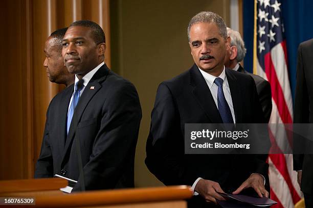 Eric Holder, U.S. Attorney general, right, arrives to a news conference with Tony West, acting associate attorney general, left, in Washington, D.C.,...