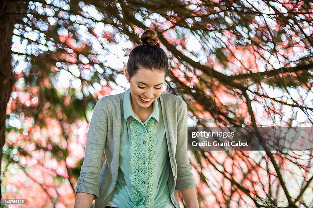 Beautiful girl laughing in front of light pink flo