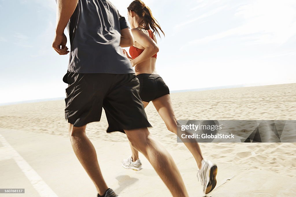 Cropped shot of man and woman running on beach