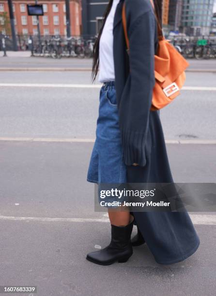 Amaka Hamelijnck seen wearing white cotton t-shirt, grey long knit cardigan, blue denim short pants, orange shoulder bag and Copenhagen Studios...