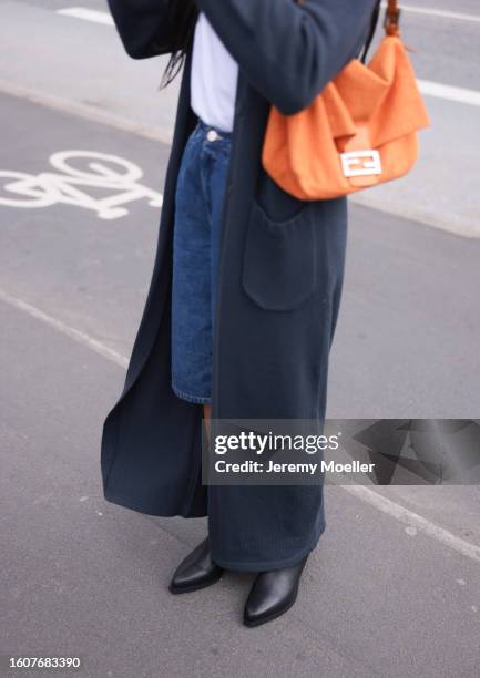 Amaka Hamelijnck seen wearing white cotton t-shirt, grey long knit cardigan, blue denim short pants, orange shoulder bag and Copenhagen Studios...