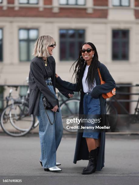 Sonja Leigh seen wearing black sunglasses, gold necklace, grey t-shirt, grey striped blazer jacket, light blue denim pants, black leather belt, black...