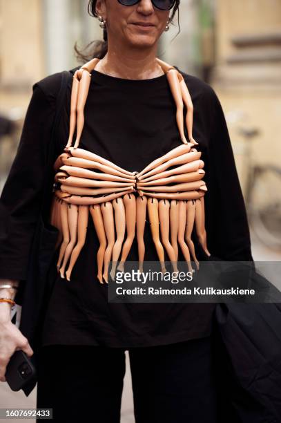 Susan Stjernberger wears a black long dress and beige bikini vest made out of Barbie doll legs outside Kernemilk during the Copenhagen Fashion Week...