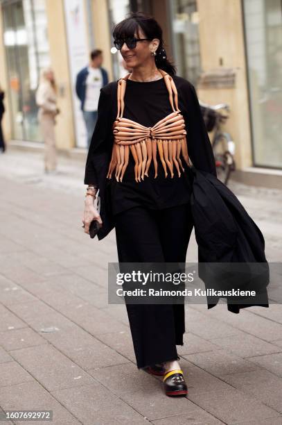 Susan Stjernberger wears a black long dress and beige bikini vest made out of Barbie doll legs outside Kernemilk during the Copenhagen Fashion Week...