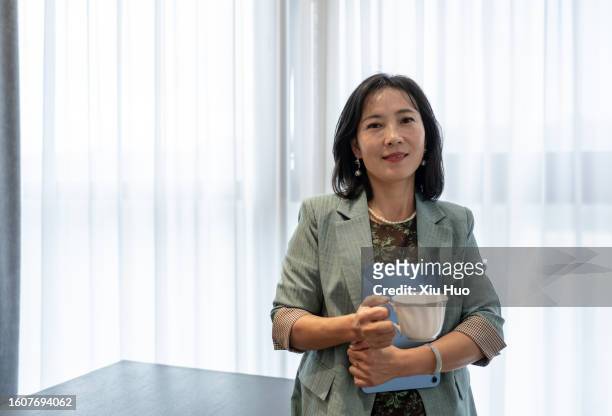 asian businesswoman is drinking coffee in front of her laptop - 活動 stock pictures, royalty-free photos & images