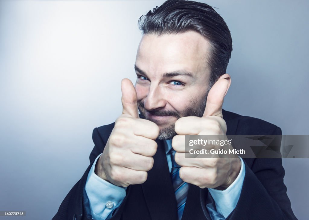 Business man with both thumbs up.